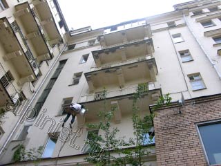 Сейчас Вы видите нашего промышленного альпиниста, который работает с плитой нижнего балкона, на фотографии видно, что два верхних балкона уже отремонтированы, бухтящая штукатурка отбита, а углы и боковые части балконной плиты оштукатурены.