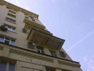 Это балконная плита с фасадной стороны, на этой плите видно облезшую краску, отваливающиеся куски  штукатурки, а трещины идут по всей плите.
