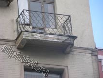 Угол балконной плиты одного из балконов сильно разрушен, уже видна торчащая арматура, штукатурка бухтит, и по ней идут глубокие трещины.