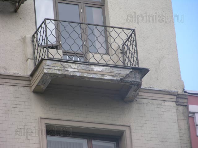 Угол балконной плиты одного из балконов сильно разрушен, уже видна торчащая арматура, штукатурка бухтит, и по ней идут глубокие трещины.
