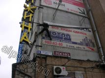 Для того, чтобы  снять репшнур с левой вертикальной стороны баннера, наш альпинист маятником раскачался на веревке и зацепился ногой за угол здания