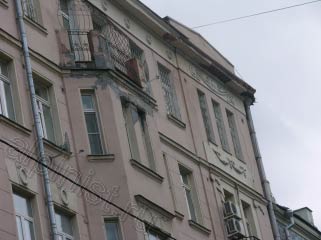 Архитектурные элементы балкона сильно разрушены, видно бухтящую штукатурку на фасаде, балкон, промазанный мастикой, местами отвалившаяся лепнина, разрушенный козырек.