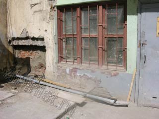 На фотографии видно разрушенный приямок, который наш мастер заложит кирпичом, после чего оштукатурит вровень со стеной фасада.