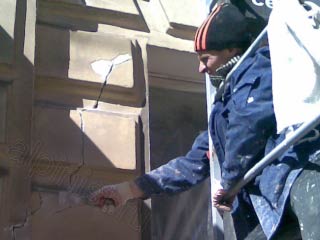 Здесь показан наш мастер, который  с туры расшивает шпателем небольшие трещины и сколы на фасаде здания.