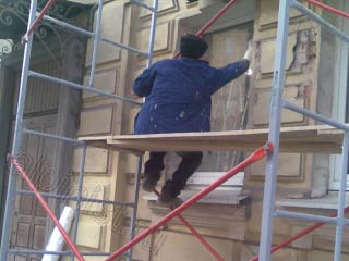 Сейчас наш специалист заклеивает окна пленкой, чтобы не запачкать их раствором во время проведения фасадных работ.