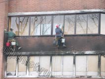 На данной фотографии показаны наши альпинисты, которые моют окна балкона и  очищают кирпичное здание специальным средством для очисти фасада после пожаров.