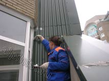На этой фотографии показано, как наш специалист промазывает специальным герметиком примыкания металлического листа к стене