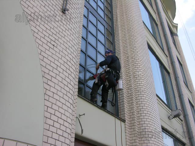 альпинист использует специальную оконную присоску, чтобы быть ближе к окну
