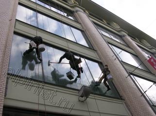 На фотографии видно, что именно делают альпинисты, один специалист  в данный момент промывает окна шубкой, а второй после мойки снимает излишки склизом.