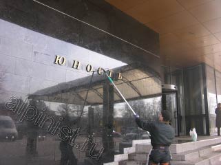 На представленной фотографии видно, как наш специалист в данный момент проводит мойку фасада, он моет мраморную стену у главного входа и буквы названия гостиницы «Юность».
