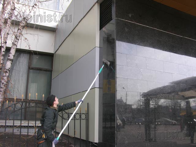 специалист моет поверхность фасада из мрамора по той же технологии, как и окна, применяя чистую воду, шубки и склизы