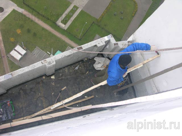 промышленный альпинист демонтирует обрешетку крыши, предварительно сняв старое кровельное покрытие