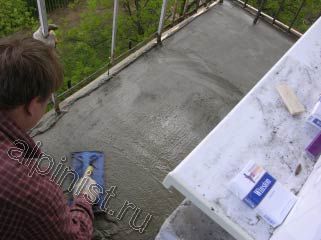 На большей части балконной плиты наш специалист провел устройство новой стяжки, сейчас он разглаживает ее теркой