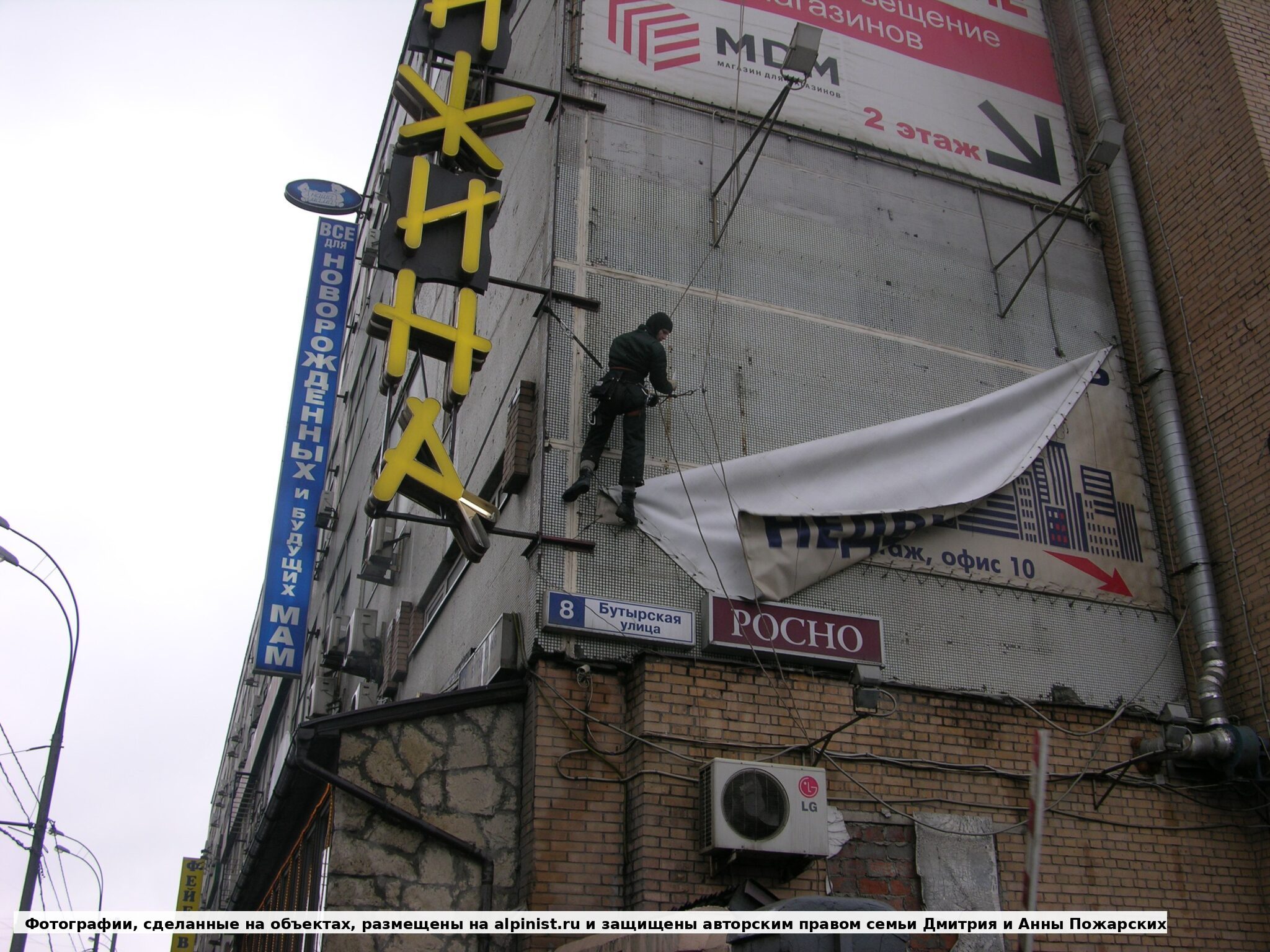 Начало сворачивания рекламного полотна после ослабления креплений