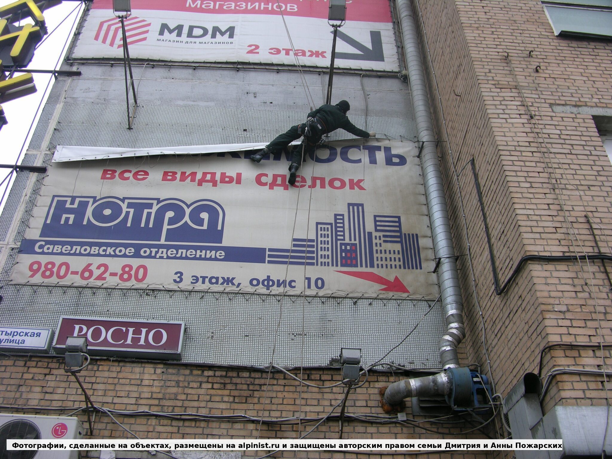 Первый участок баннера после снятия части креплений на торце фасада